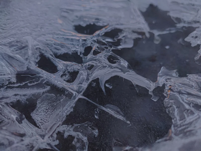 Close-up of cracked ice with dark water beneath