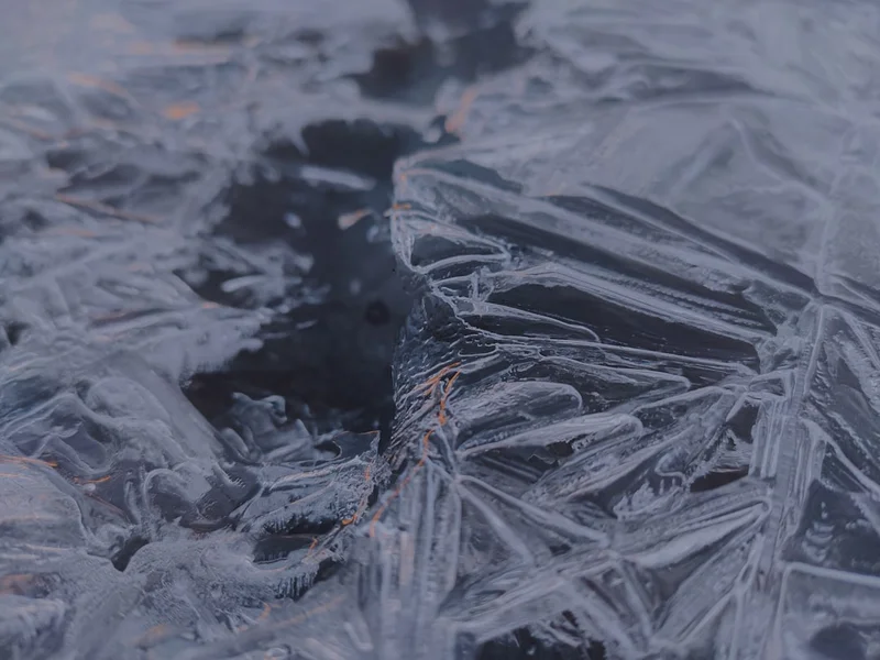 Close-up of jagged ice formations on a dark surface.